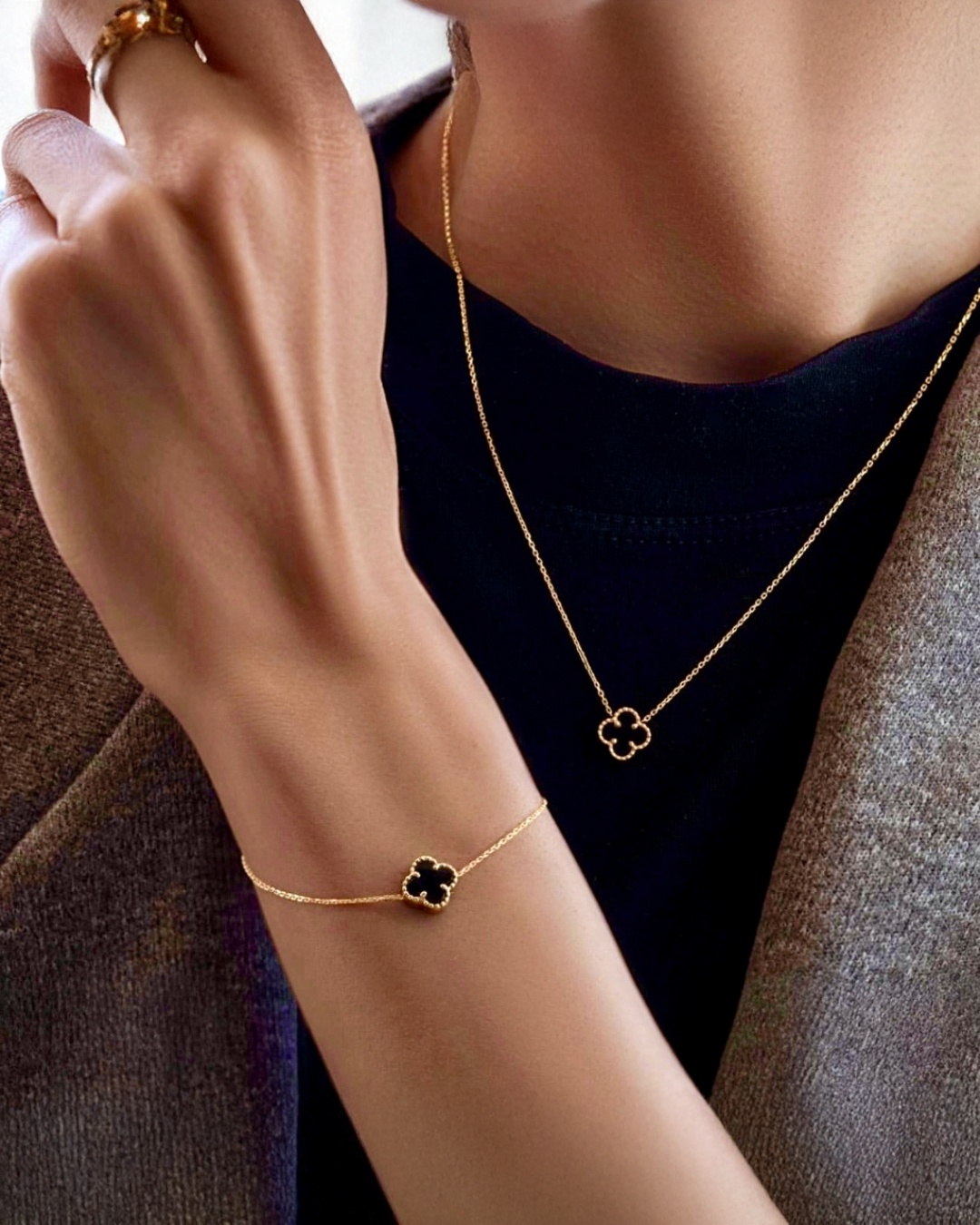 Feines Armband aus 18k Gelbgold mit zartem Kleeblatt-Anhänger in Schwarz und Gold, filigran gearbeitet – luxuriöses zweifarbiges Glücksarmband.