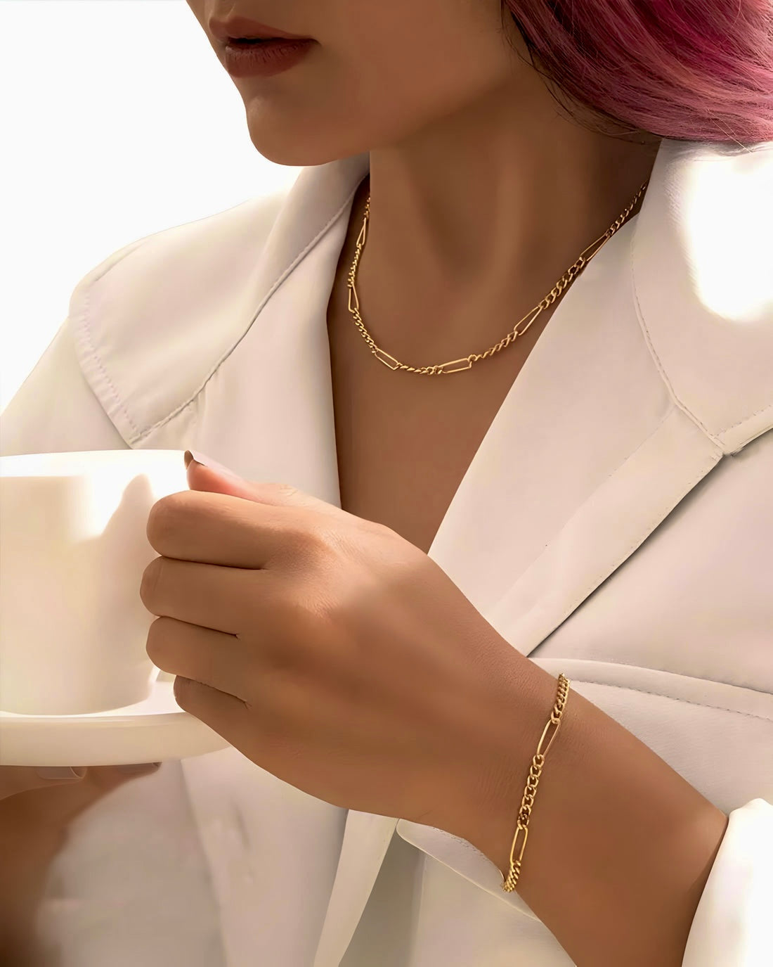 Elegante Halskette aus 18k Gelbgold – Zanjir-e Figaro (Figaro Kette), getragen von einer Frau in weißem Blazer, modernes Styling, feine Gliederstruktur, luxuriöser Goldschmuck.