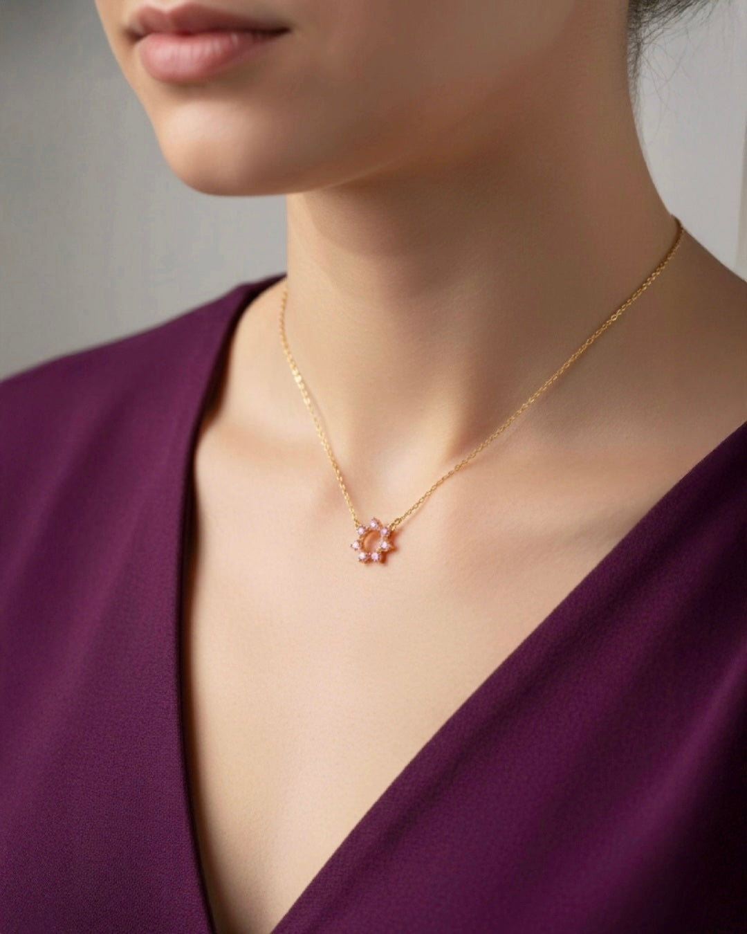 Detailaufnahme einer filigranen 18k Gelbgold-Halskette mit rosafarbenem Edelstein-Anhänger, elegant getragen am Dekolleté – hochwertiger Goldschmuck von Ziba Gold