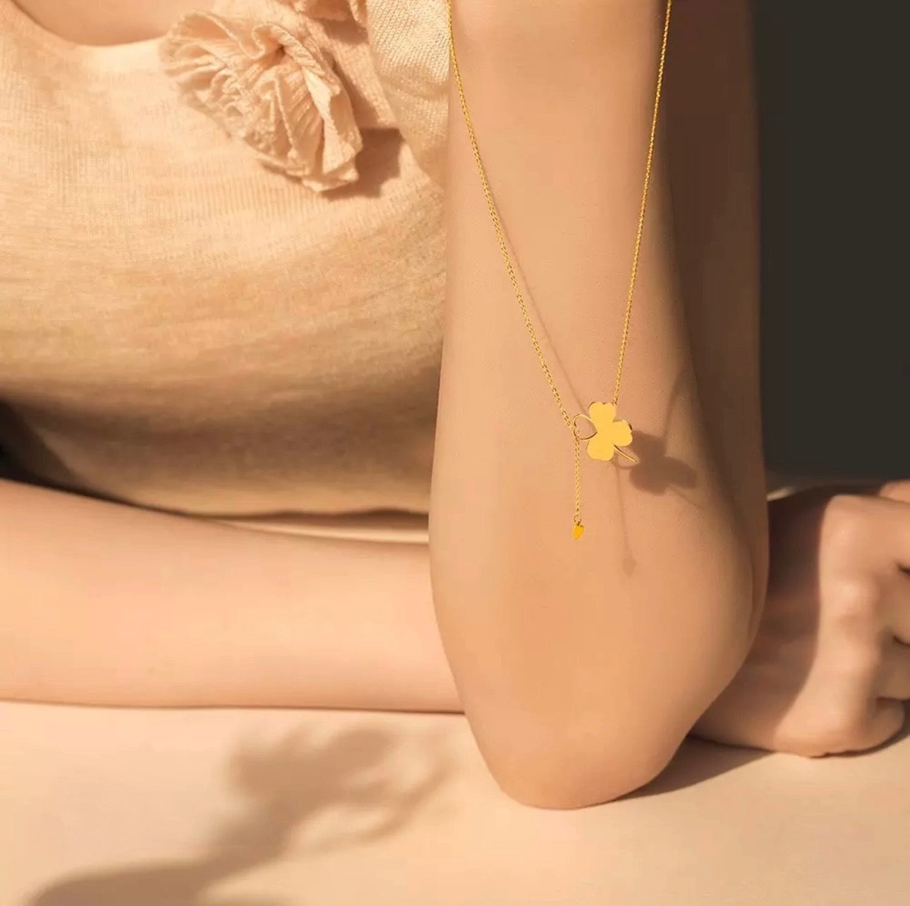 Halskette ‚Shabdar-e Eshgh‘ aus 18k Gold mit Kleeblatt-Motiv und schwebendem Herzsymbol – inszeniert im natürlichen Licht