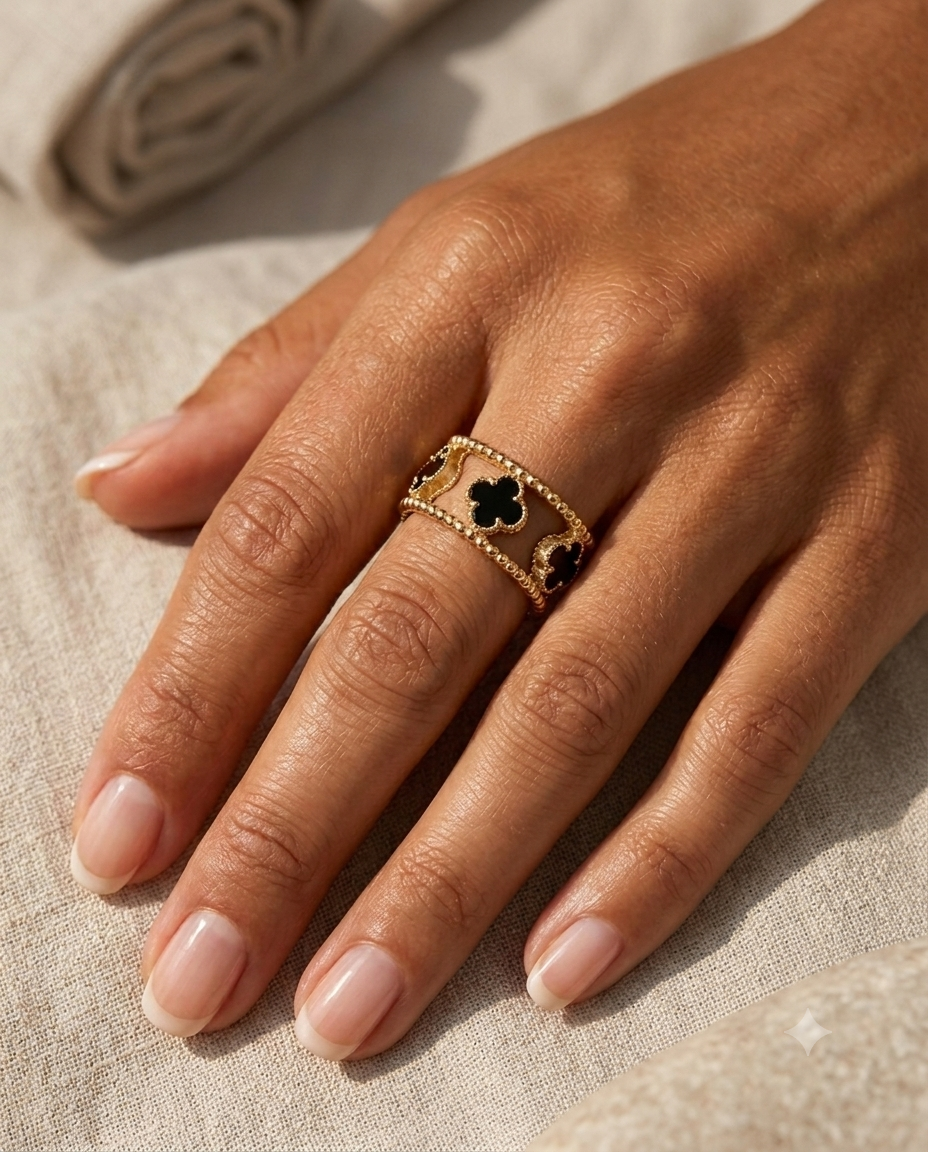 Breiter Goldring mit Onyx-Kleeblättern getragen an der Hand