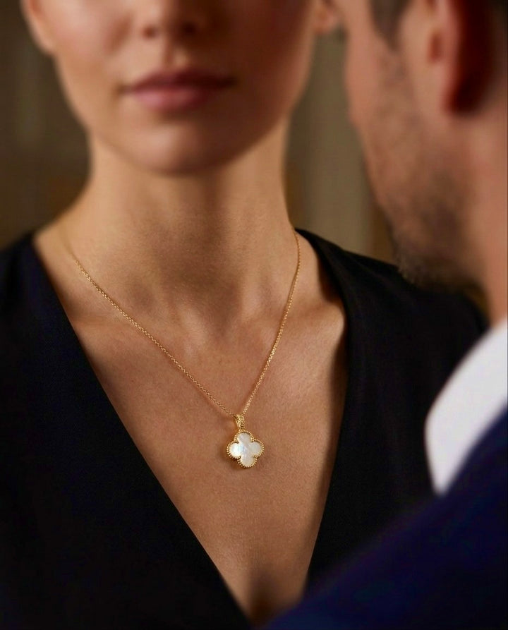 Elegante 18 Karat Gelbgold-Halskette mit vierblättrigem Kleeblatt-Anhänger aus schimmerndem Perlmutt. Der filigrane Anhänger symbolisiert Glück, Harmonie und zeitlose Eleganz. Handgefertigter Goldschmuck für Damen – stilvoll kombiniert mit einem schwarzen Kleid und ideal für Alltag sowie besondere Anlässe.