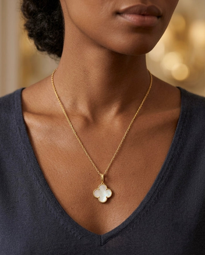 Elegante 18 Karat Gelbgold-Halskette mit vierblättrigem Kleeblatt-Anhänger aus schimmerndem Perlmutt. Der filigrane Glücksbringer steht für Glück, Liebe, Hoffnung und Harmonie. Handgefertigter Damenschmuck mit zeitlosem Design – stilvoll getragen zu einem dunklen V-Ausschnitt und perfekt für Alltag sowie besondere Anlässe.