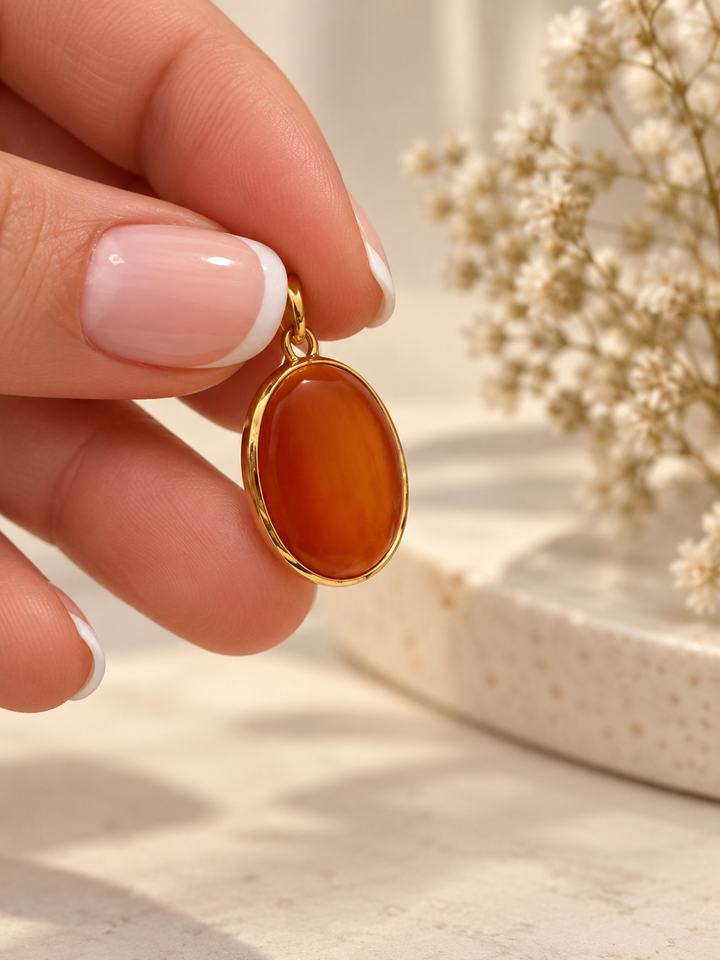 Ovaler Akhgar Anhänger aus 18K Gelbgold mit synthetischem Schmuckstein in tiefem Rot und polierter Goldfassung.