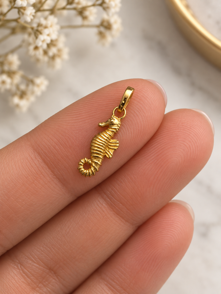Kleiner Seepferdchen-Anhänger Asb-e Daryayi aus 18k Gelbgold auf der Hand