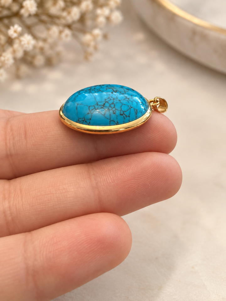 Nahaufnahme des Aseman Anhängers mit blauem Schmuckstein, dunkler netzartiger Zeichnung und Einfassung aus 18k Gelbgold