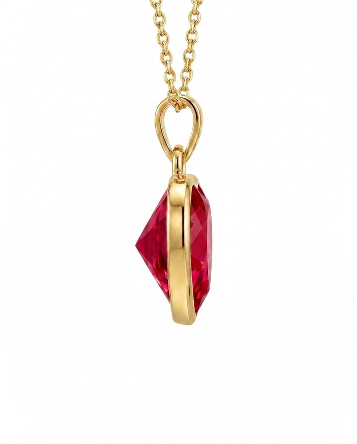 Seitenansicht eines Herzanhängers aus 18k Gelbgold mit facettierter roter Zirkonia.