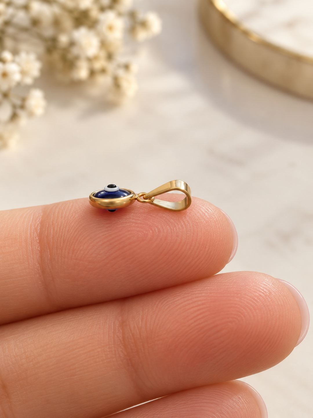 Detailaufnahme des blauen Schutzauges mit weissem und schwarzem Augenmotiv in 18k Gelbgoldfassung