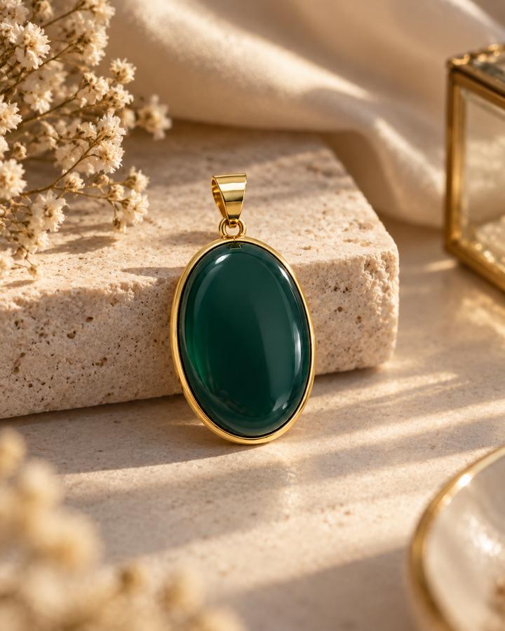 Del-e Jangal Anhänger aus 18k Gelbgold mit tiefgrünem Schmuckstein in warmer Editorial-Aufnahme