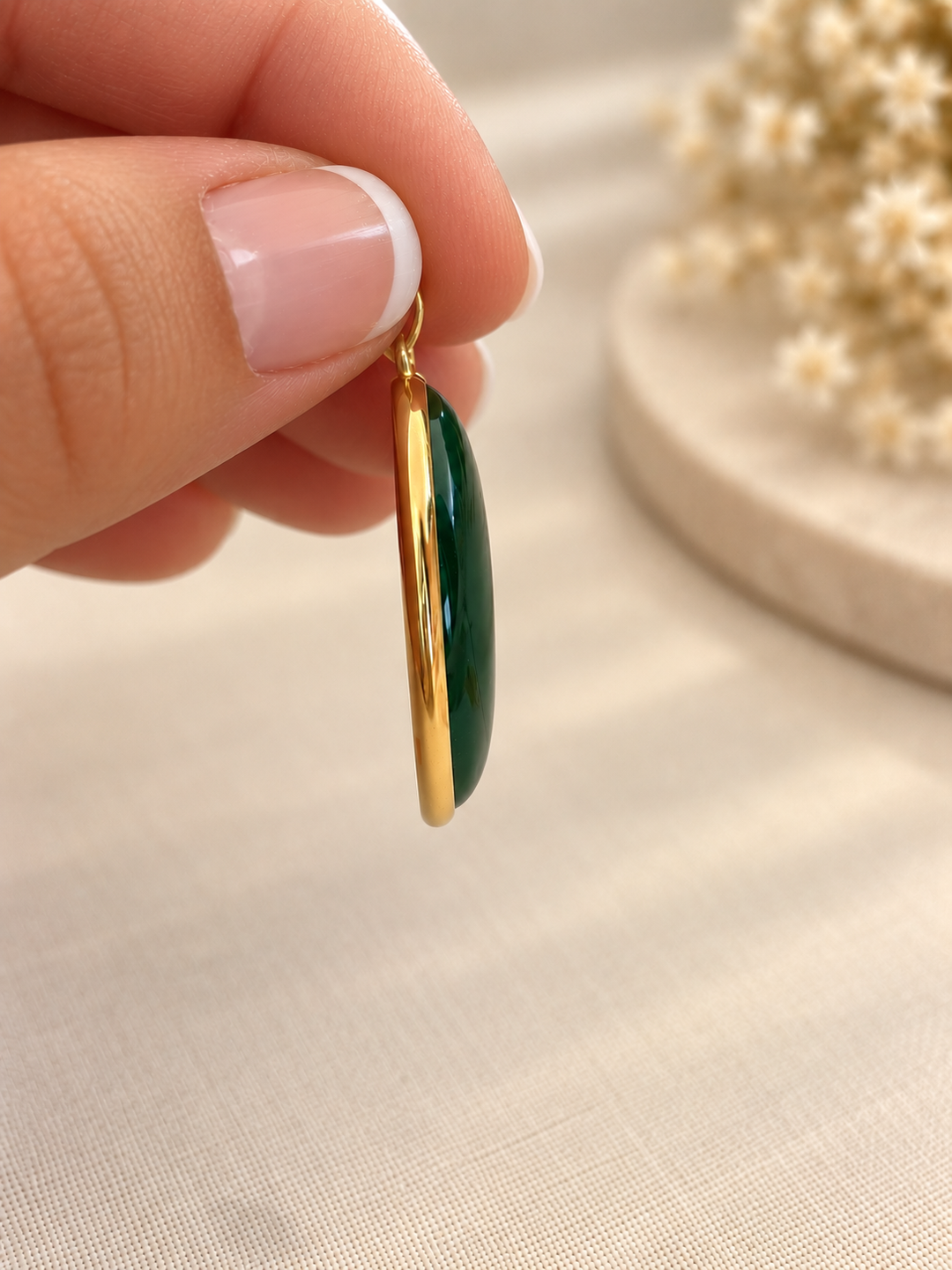 Seitenprofil des gewölbten grünen Schmucksteins mit hochglanzpolierter 18k Goldfassung