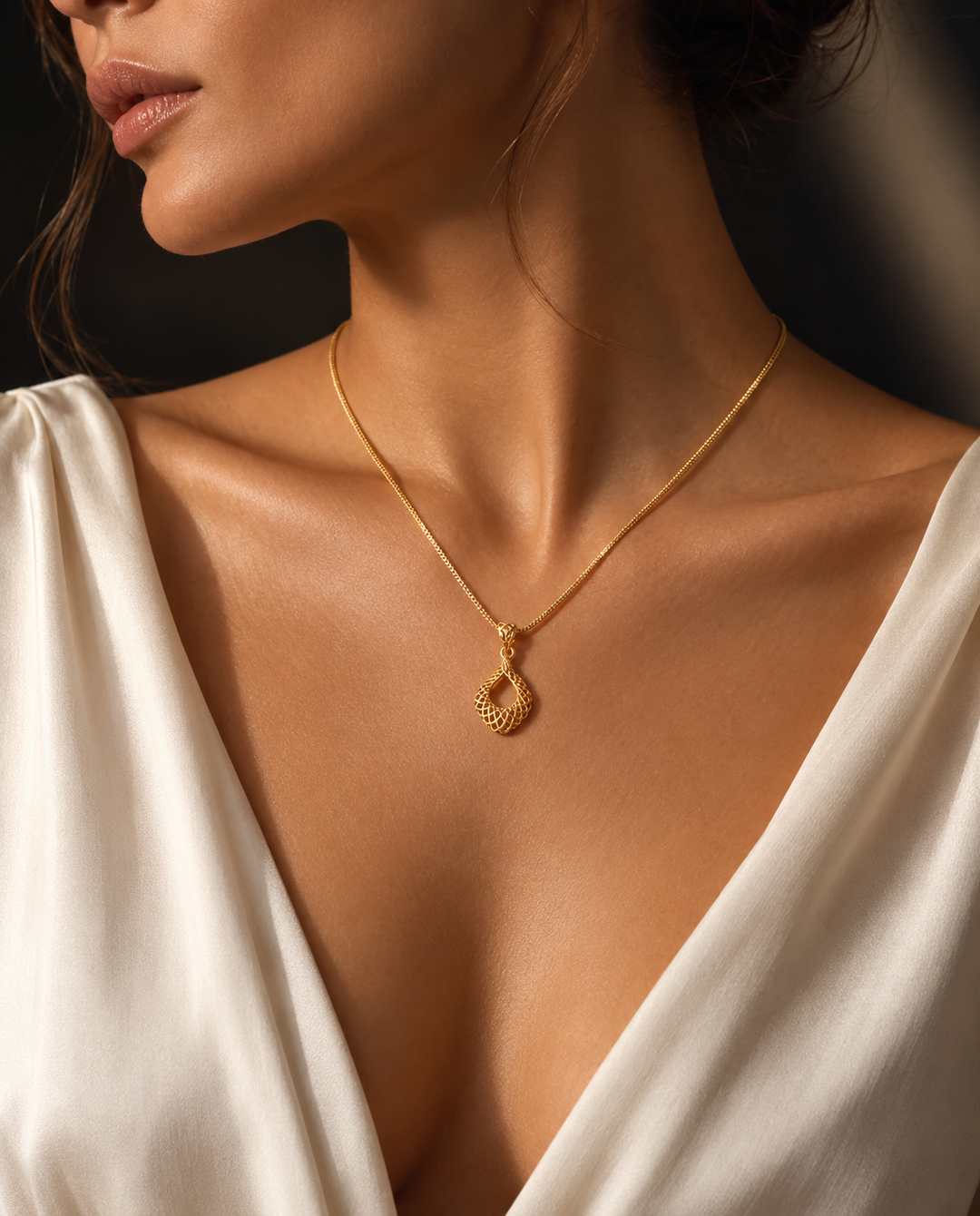 Elegante 18 Karat Gelbgold-Halskette mit filigranem tropfenförmigem Anhänger in persischem Design, getragen von einem weiblichen Model. Der handgefertigte Goldanhänger mit feiner Struktur wird stilvoll auf einem cremefarbenen Kleid präsentiert und unterstreicht zeitlose Eleganz sowie luxuriösen Schmuck für Damen.