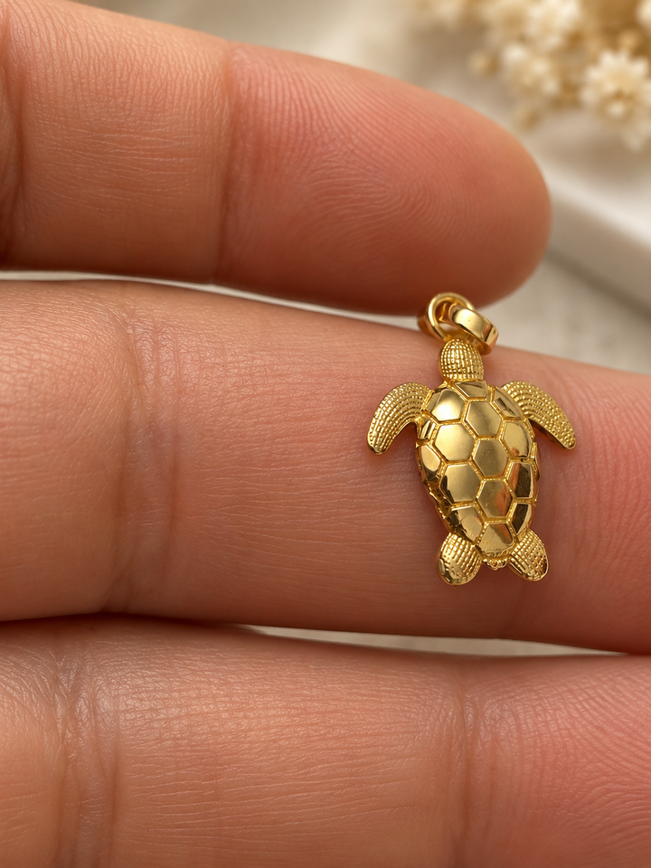 Kleiner Lakposht Meeresschildkröten-Anhänger aus 18k Gelbgold mit fein ausgearbeiteten Flossen auf der Hand