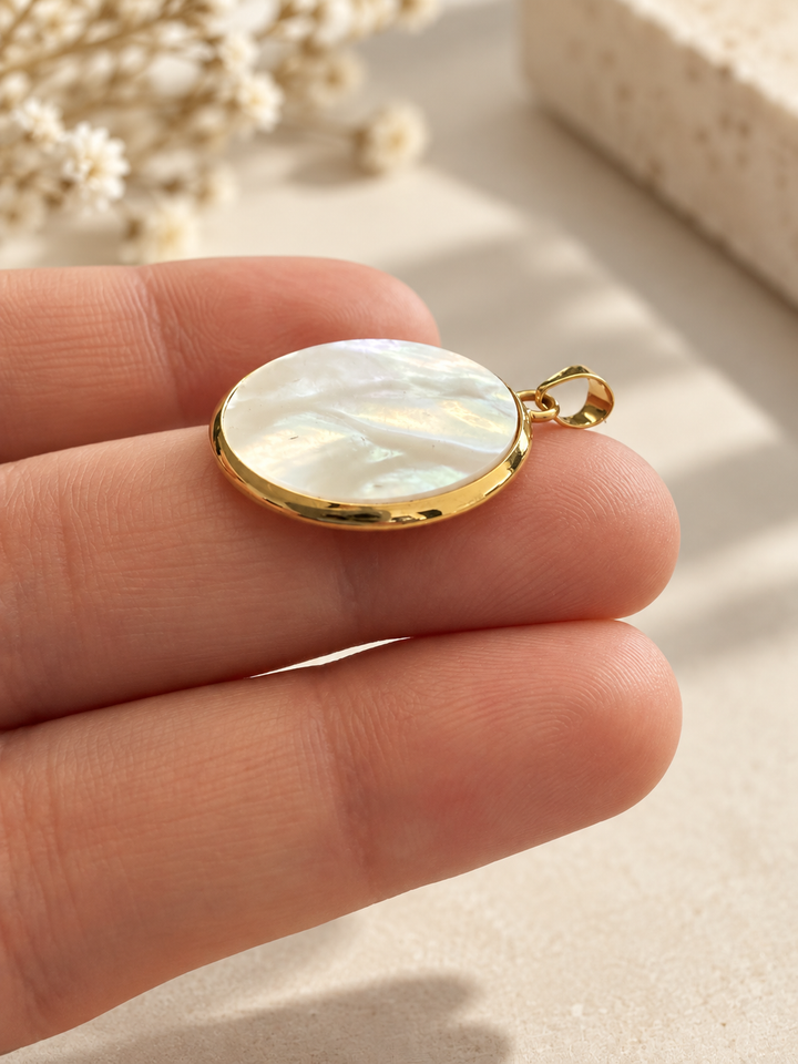 Mah-e Sadaf Anhänger aus 18k Gelbgold mit rundem weissem Perlmutt und irisierendem Schimmer auf der Hand