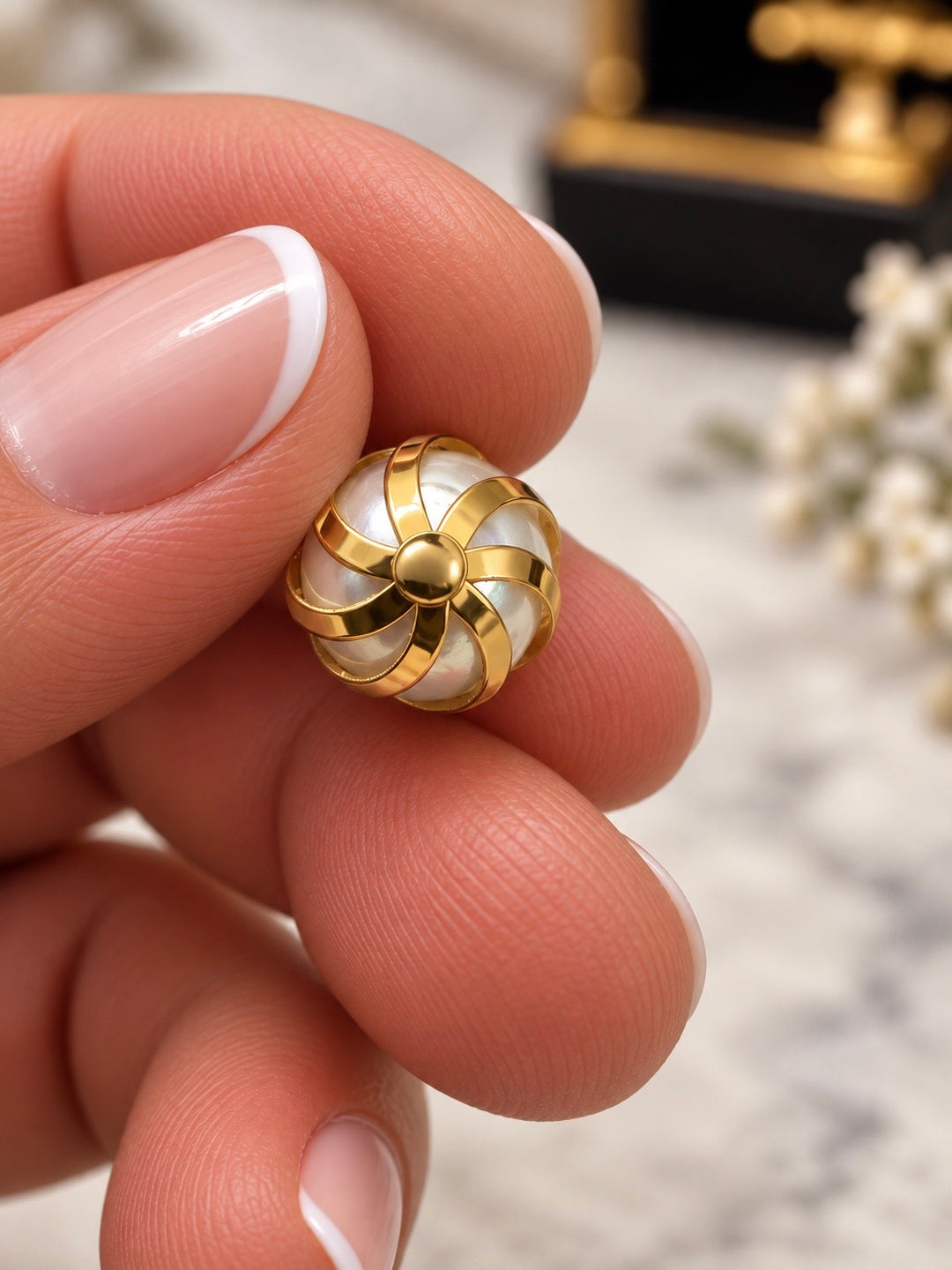 Rückansicht des Perlenanhängers aus 18k Gelbgold mit sternförmig zusammenlaufenden Goldbändern.