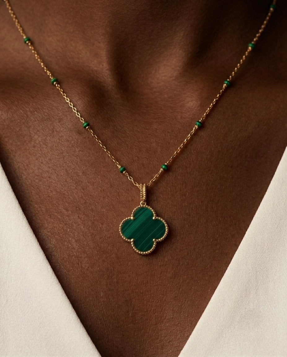 Elegante Damen Halskette aus 18 Karat Gelbgold mit grünem Malachit-Kleeblatt-Anhänger und feiner Gliederkette mit Malachit-Details. Exklusiver Goldschmuck im zeitlosen Design für Alltag, Business und besondere Anlässe.
