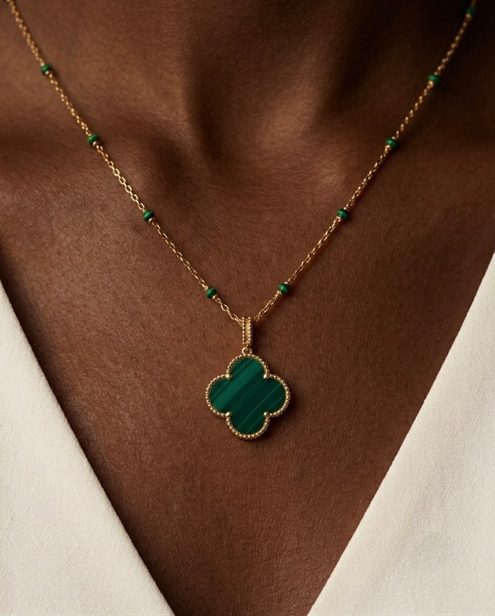 Elegante Damen Halskette aus 18 Karat Gelbgold mit grünem Malachit-Kleeblatt-Anhänger und feiner Gliederkette mit Malachit-Details. Exklusiver Goldschmuck im zeitlosen Design für Alltag, Business und besondere Anlässe.