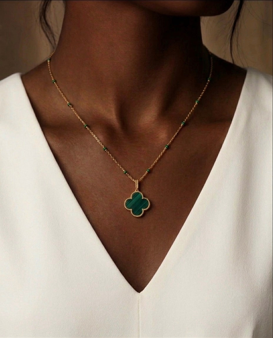 Damen Halskette aus 18 Karat Gelbgold mit grünem Kleeblatt-Malachit-Anhänger, getragen am Hals. Eleganter Goldschmuck mit feiner Gliederkette und grünen Akzenten – zeitlos, feminin und ideal für Alltag sowie besondere Anlässe.