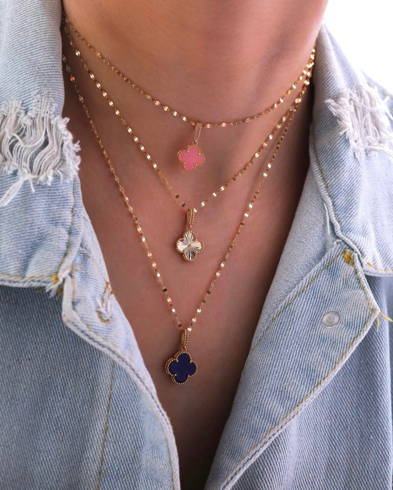 Feiner Anhänger aus 18k Gelbgold in Kleeblattform mit zartrosa Inlay, filigran gefasst an einer eleganten Goldkette – luxuriöser kleiner Glücksanhänger.