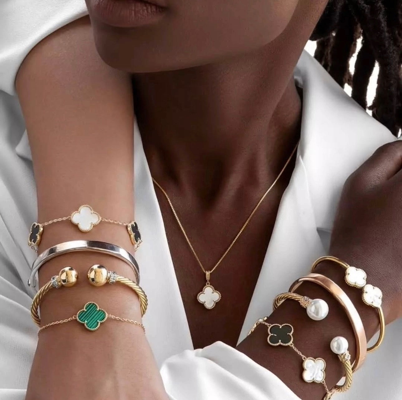 Luxuriöser Anhänger aus 18k Gelbgold in Kleeblattform mit weißem Inlay, filigran gefasst und an feiner Goldkette getragen – eleganter Glücksbringer-Schmuck.