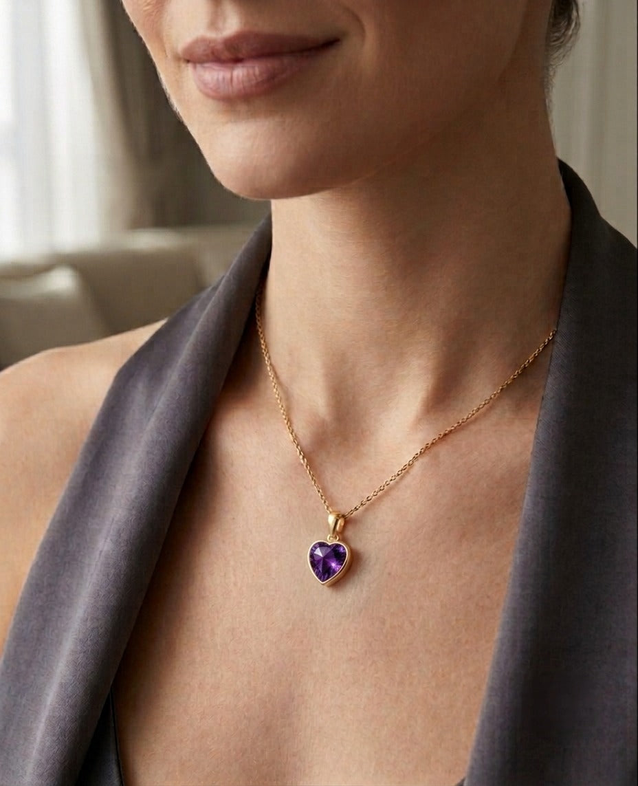 Herzanhänger aus 18k Gelbgold mit violetter Zirkonia, getragen an einer feinen Goldkette.