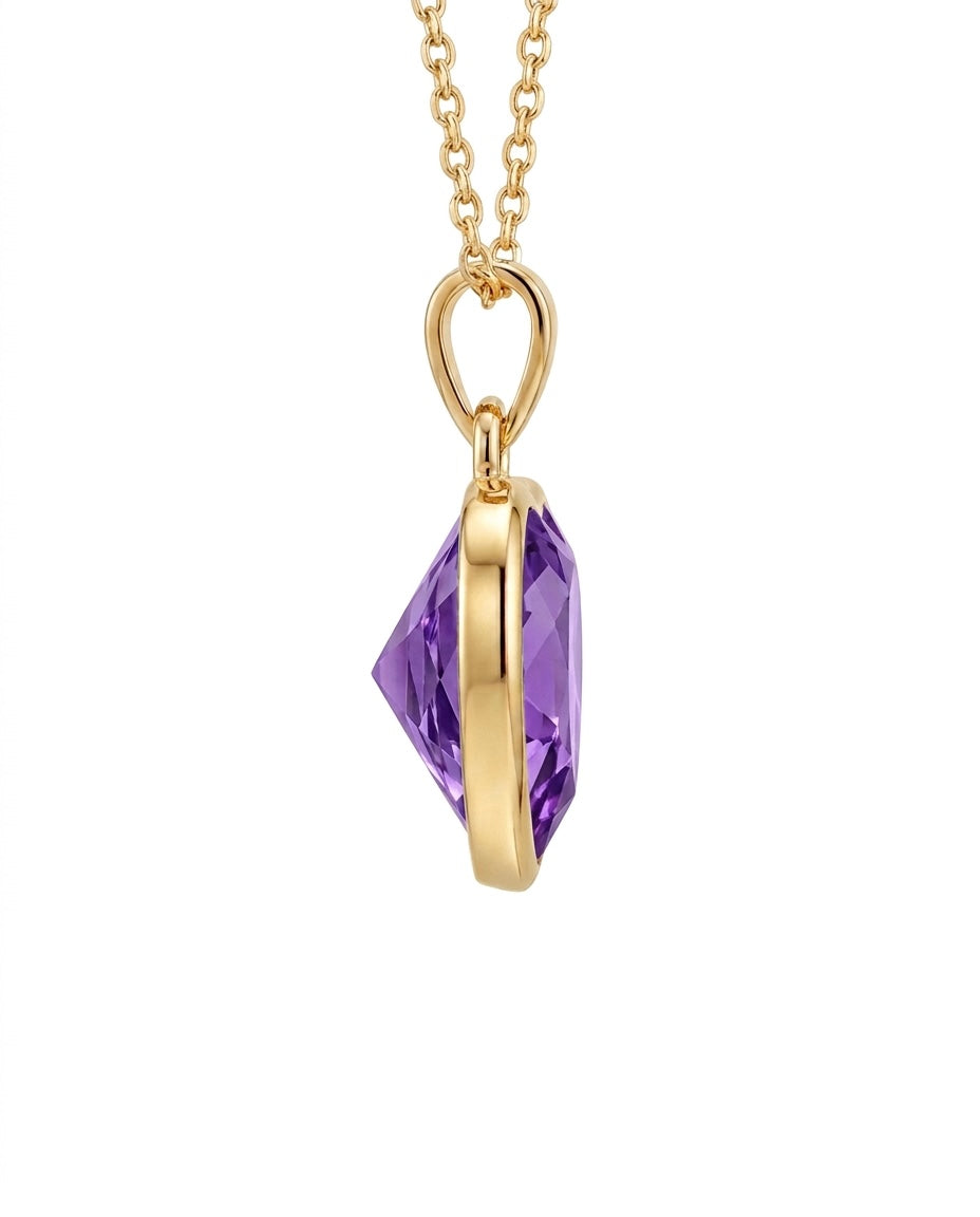 Filigraner Herzanhänger aus 18k Gelbgold mit violetter Zirkonia als Freisteller.