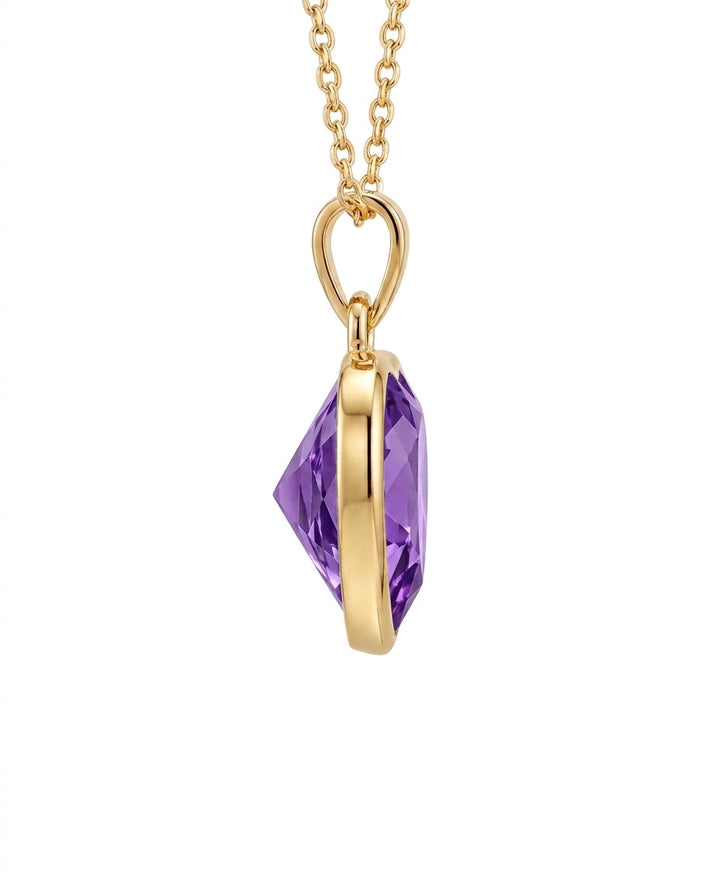 Filigraner Herzanhänger aus 18k Gelbgold mit violetter Zirkonia als Freisteller.