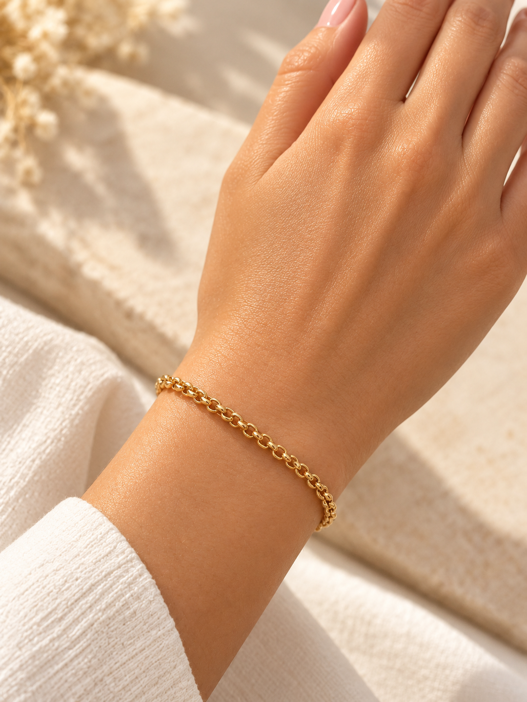 Elegantes Rolo-Goldarmband aus 18K Gelbgold mit 3,6 mm breiter Erbskette, getragen am Handgelenk zu heller Kleidung.