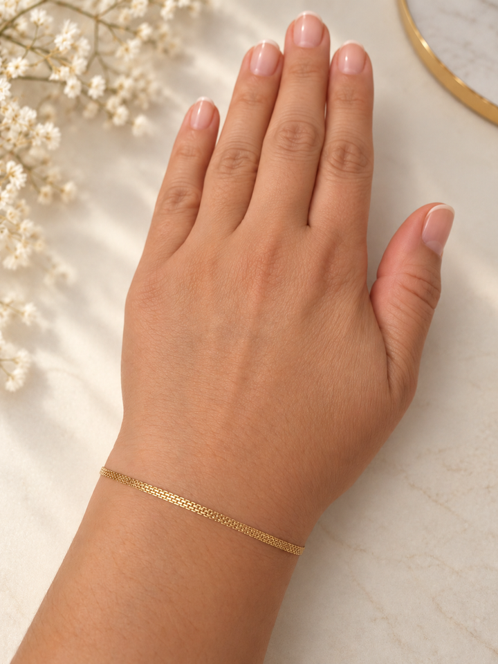 Filigranes Bismarck-Armband aus 18 Karat Gelbgold von Ziba Gold, einzeln am Handgelenk getragen, mit feiner goldener Kettenstruktur.