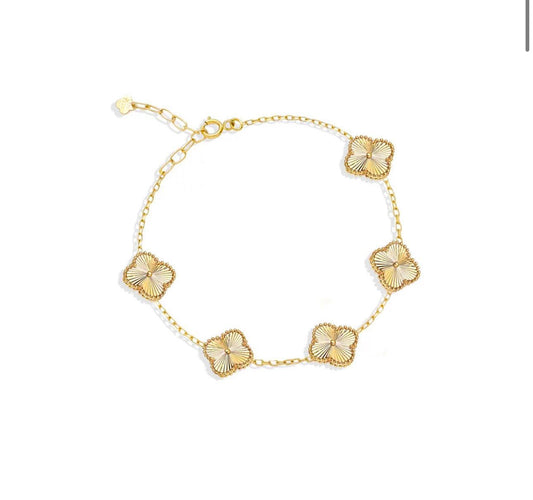 Armband aus 18k Gelbgold mit fünf filigranen Kleeblatt-Elementen – freigestellt.