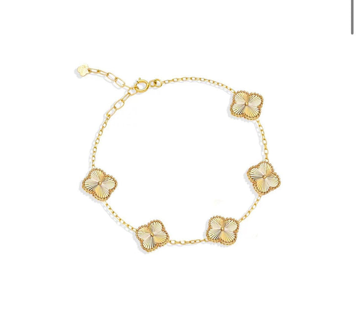 Armband aus 18k Gelbgold mit fünf filigranen Kleeblatt-Elementen – freigestellt.