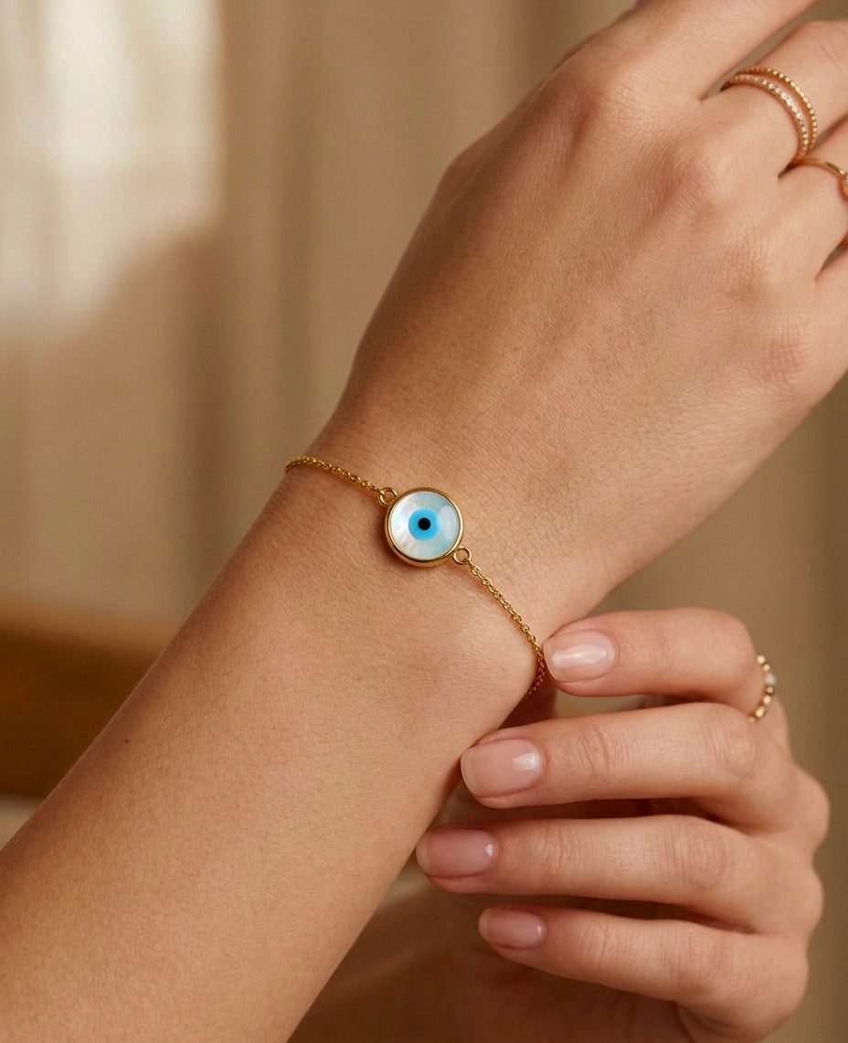 18 Karat Gold Armband mit blauem Nazar-Auge und Perlmutt, filigran am Handgelenk getragen.