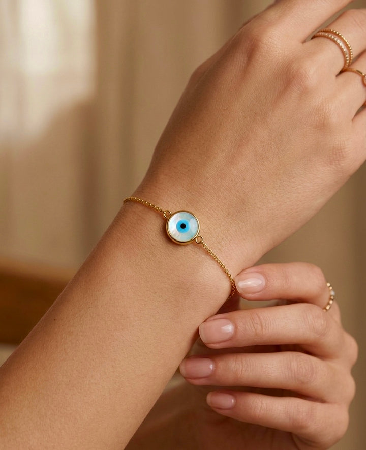 18 Karat Gold Armband mit blauem Nazar-Auge und Perlmutt, filigran am Handgelenk getragen.