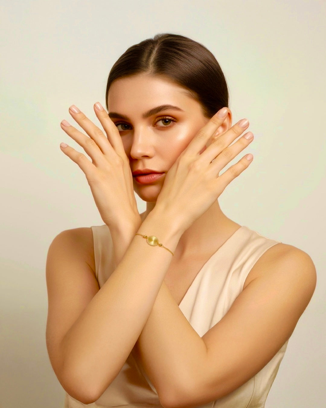Elegantes Model mit minimalistischem 18k Goldarmband mit rundem, strukturiertem Medaillon-Element – feines Luxus-Schmuckstück an zarter Goldkette.