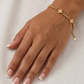 Detailaufnahme eines 18k Goldarmbands mit Goldkugeln und fünf Blütenmotiven