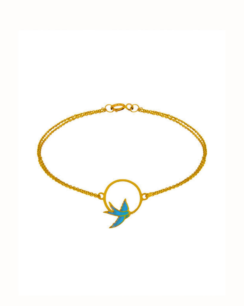 Armband aus 18k Gelbgold mit emaillierter Schwalbe im Kreis & doppelter Kette – freigestelltes Produktbild auf weissem Hintergrund.