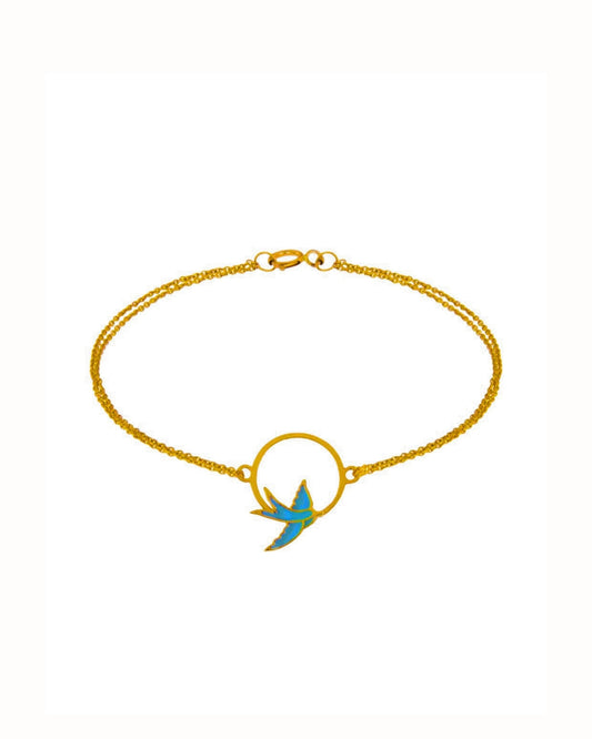 Armband aus 18k Gelbgold mit emaillierter Schwalbe im Kreis & doppelter Kette – freigestelltes Produktbild auf weissem Hintergrund.
