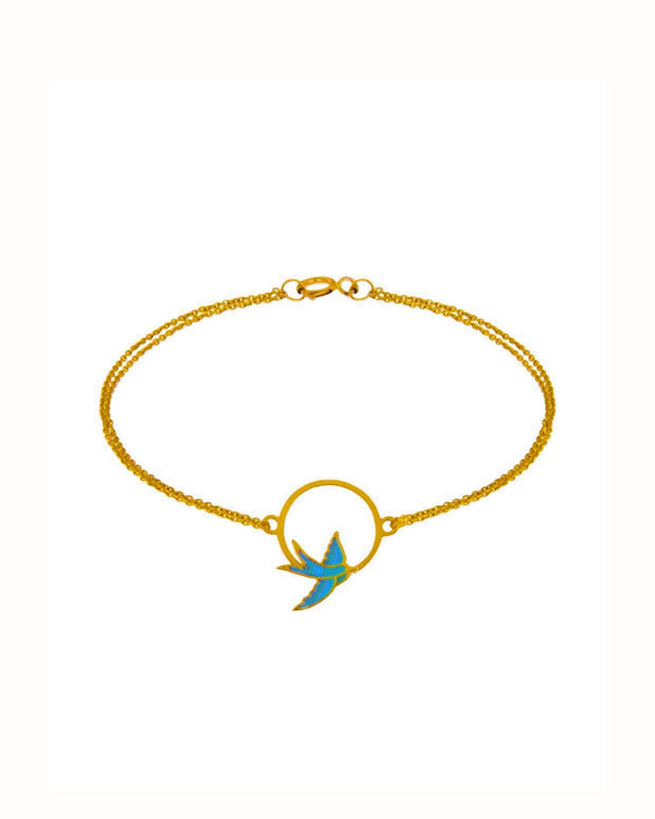 Armband aus 18k Gelbgold mit emaillierter Schwalbe im Kreis &amp; doppelter Kette – freigestelltes Produktbild auf weissem Hintergrund.