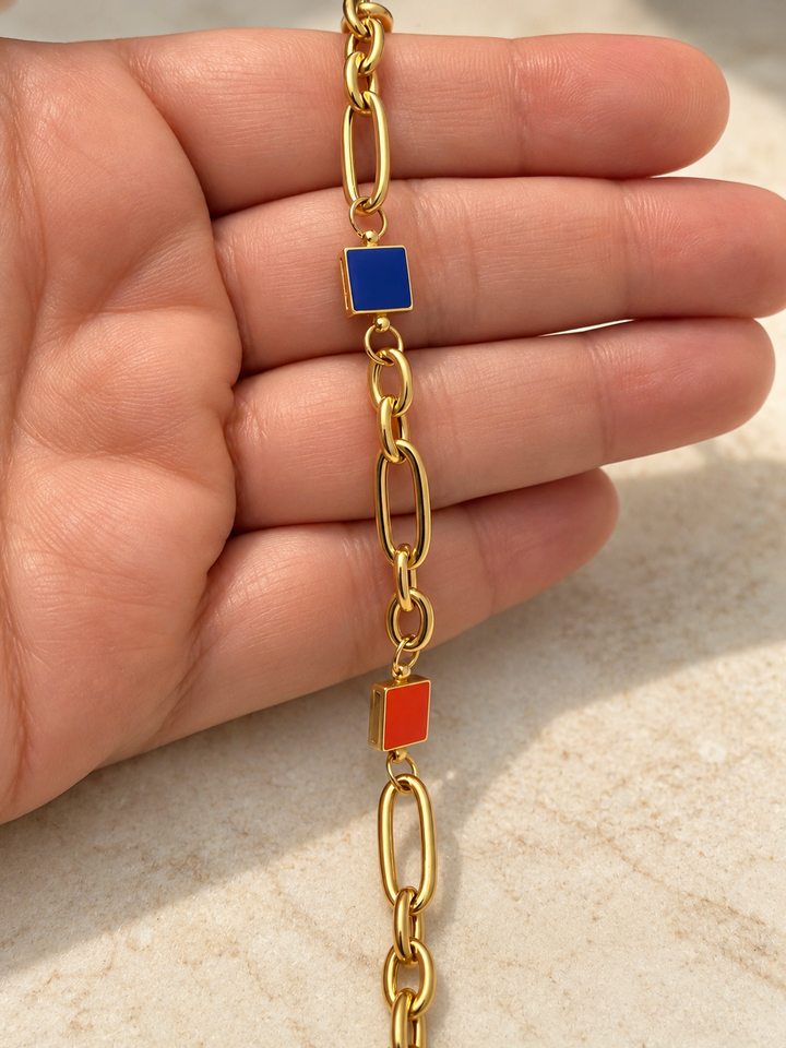 Nahaufnahme des blauen quadratischen Farbakzents am goldenen Gliederarmband Rangin aus 18 Karat Gelbgold.