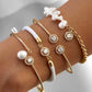 Mehrere Armbänder aus 18 Karat Gelbgold mit Zirkonia, echter Süsswasserperle, weissen Barockperlen und hochwertigem Textilband am Handgelenk. Handgefertigter Luxusschmuck mit modernem Design, der Eleganz, Individualität und zeitlose Schönheit vereint. Ideal für stilbewusste Frauen mit Sinn für besondere Schmuckstücke.
