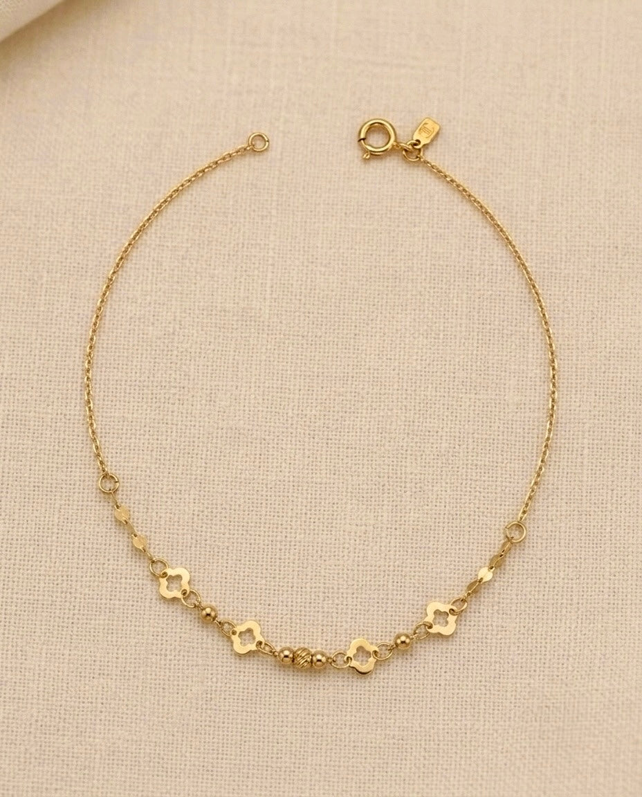 Zartes 18 Karat Goldarmband mit filigraner Ankerkette, vier Kleeblatt-Elementen und polierten Goldkugeln. Elegantes Damenarmband aus echtem Gold – zeitlos, feminin und ideal für Alltag sowie besondere Anlässe.