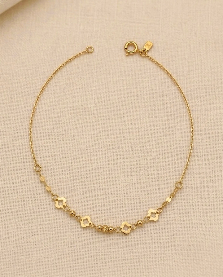 Zartes 18 Karat Goldarmband mit filigraner Ankerkette, vier Kleeblatt-Elementen und polierten Goldkugeln. Elegantes Damenarmband aus echtem Gold – zeitlos, feminin und ideal für Alltag sowie besondere Anlässe.