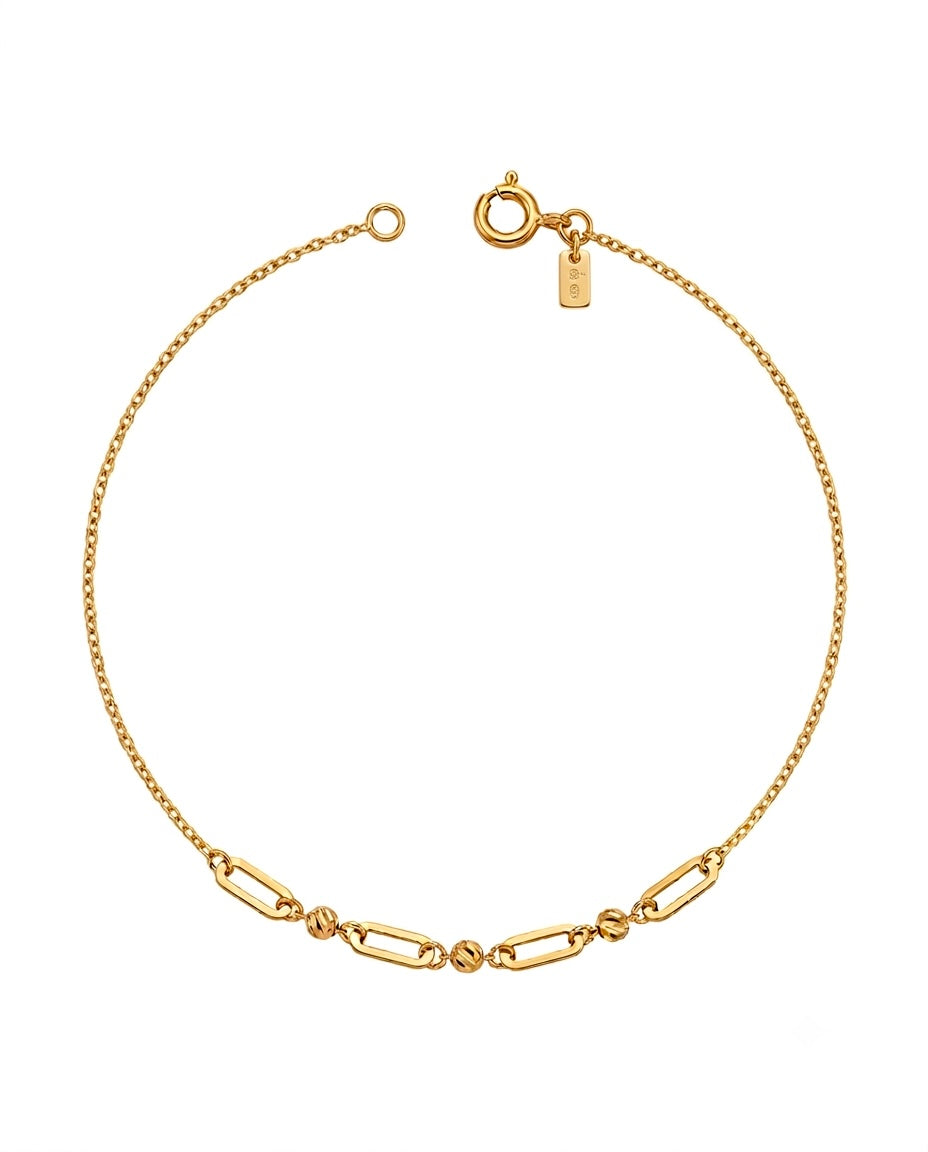 Feines Armband aus 18k Gelbgold mit abwechselnden Paperclip- und Kugel-Elementen, freigestelltes Produktbild