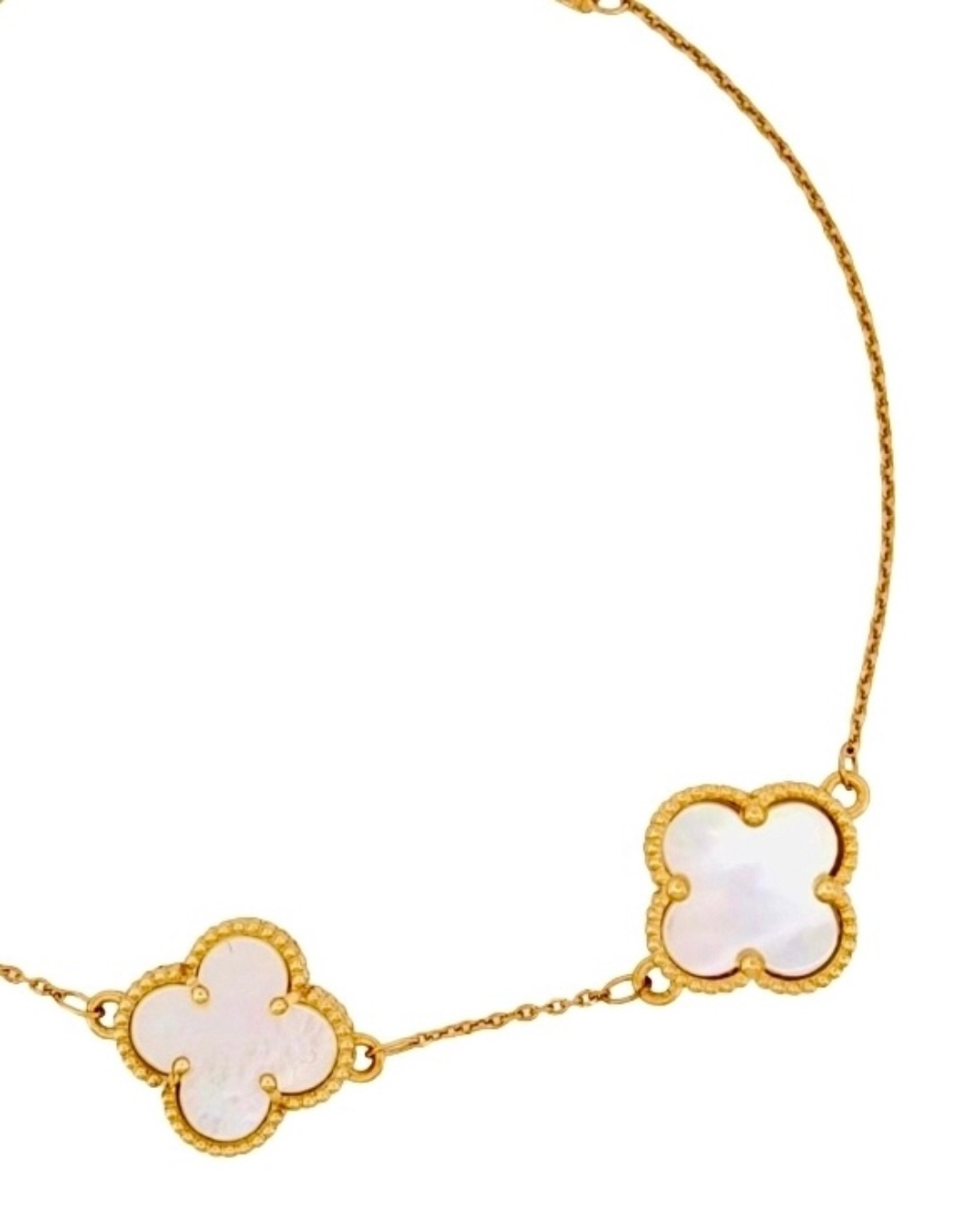 Detailaufnahme der weissen Perlmutt-Kleeblätter in goldener Perlenfassung