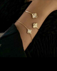 Elegantes Armband aus 18k Gelbgold mit zweifarbigem Kleeblatt-Anhänger – Shabdar-e Do Rang. Fein gearbeitete Details, Symbol für Glück und Stil.