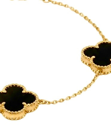 Detailaufnahme der schwarzen Kleeblätter mit goldener Fassung am Armband