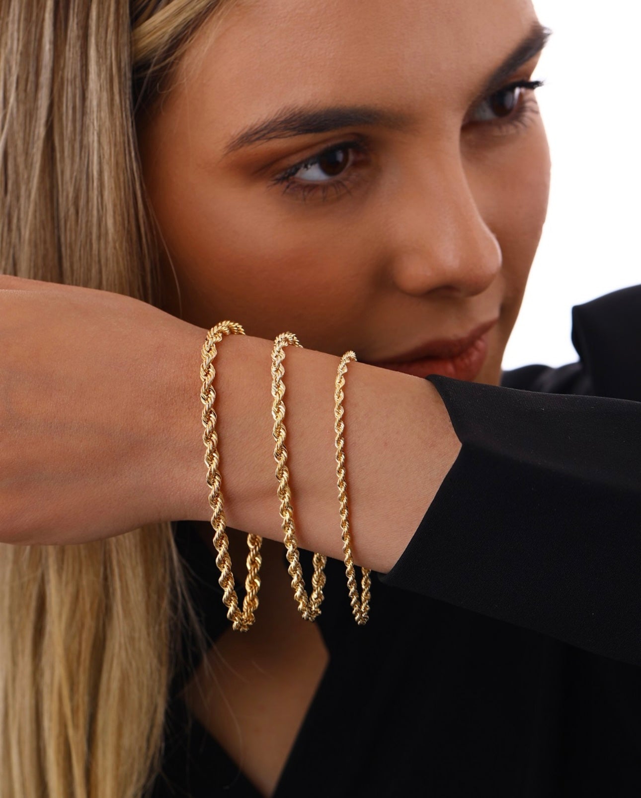 Drei goldene Kordelarmbänder Tanab-e Tala aus 18k Gelbgold – getragen am Unterarm, gedrehtes Design in verschiedenen Stärken