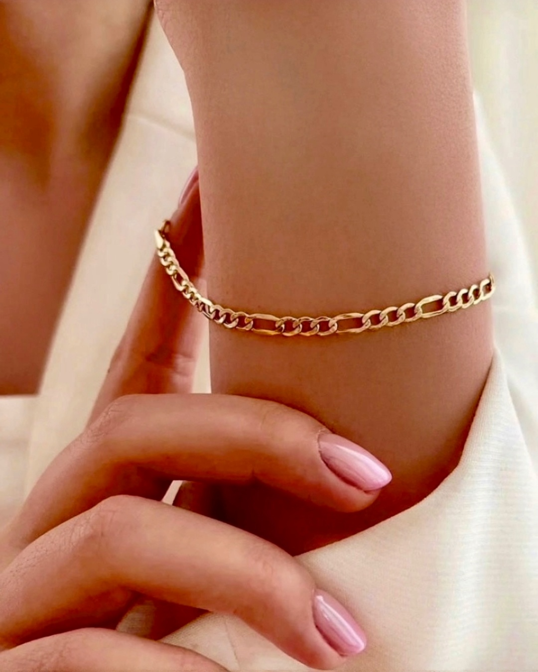 Zartes Figaro-Armband aus 18 Karat Gelbgold am Handgelenk getragen – eleganter, feiner Goldschmuck aus massivem 18k Gold, zeitlos und stilvoll für den Alltag.