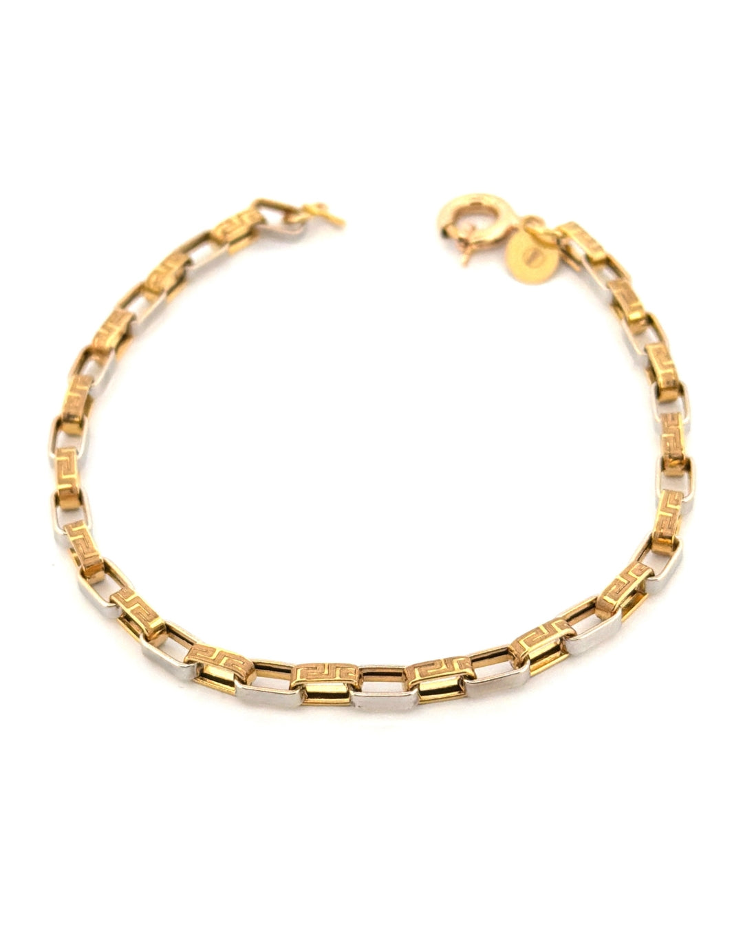 Elegantes Armband aus 18-karätigem Gelb- und Weissgold mit rechteckigen Gliedern in modernem, geometrischem Design. Die polierten Weissgold-Elemente wechseln sich mit Gelbgold-Gliedern ab, die mit einem feinen griechischen Schlüsselmuster graviert sind. Das Armband ist auf hellem Hintergrund freigestellt fotografiert und wirkt durch die Kombination der beiden Goldfarben zeitlos, edel und stilvoll.