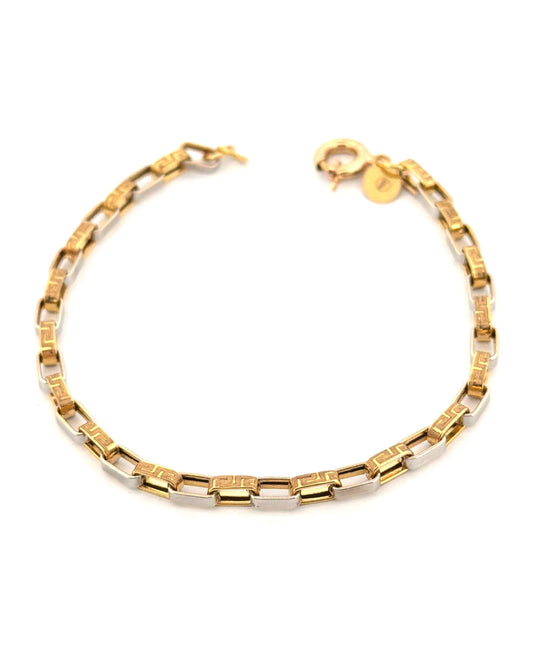 Elegantes Armband aus 18-karätigem Gelb- und Weissgold mit rechteckigen Gliedern in modernem, geometrischem Design. Die polierten Weissgold-Elemente wechseln sich mit Gelbgold-Gliedern ab, die mit einem feinen griechischen Schlüsselmuster graviert sind. Das Armband ist auf hellem Hintergrund freigestellt fotografiert und wirkt durch die Kombination der beiden Goldfarben zeitlos, edel und stilvoll.