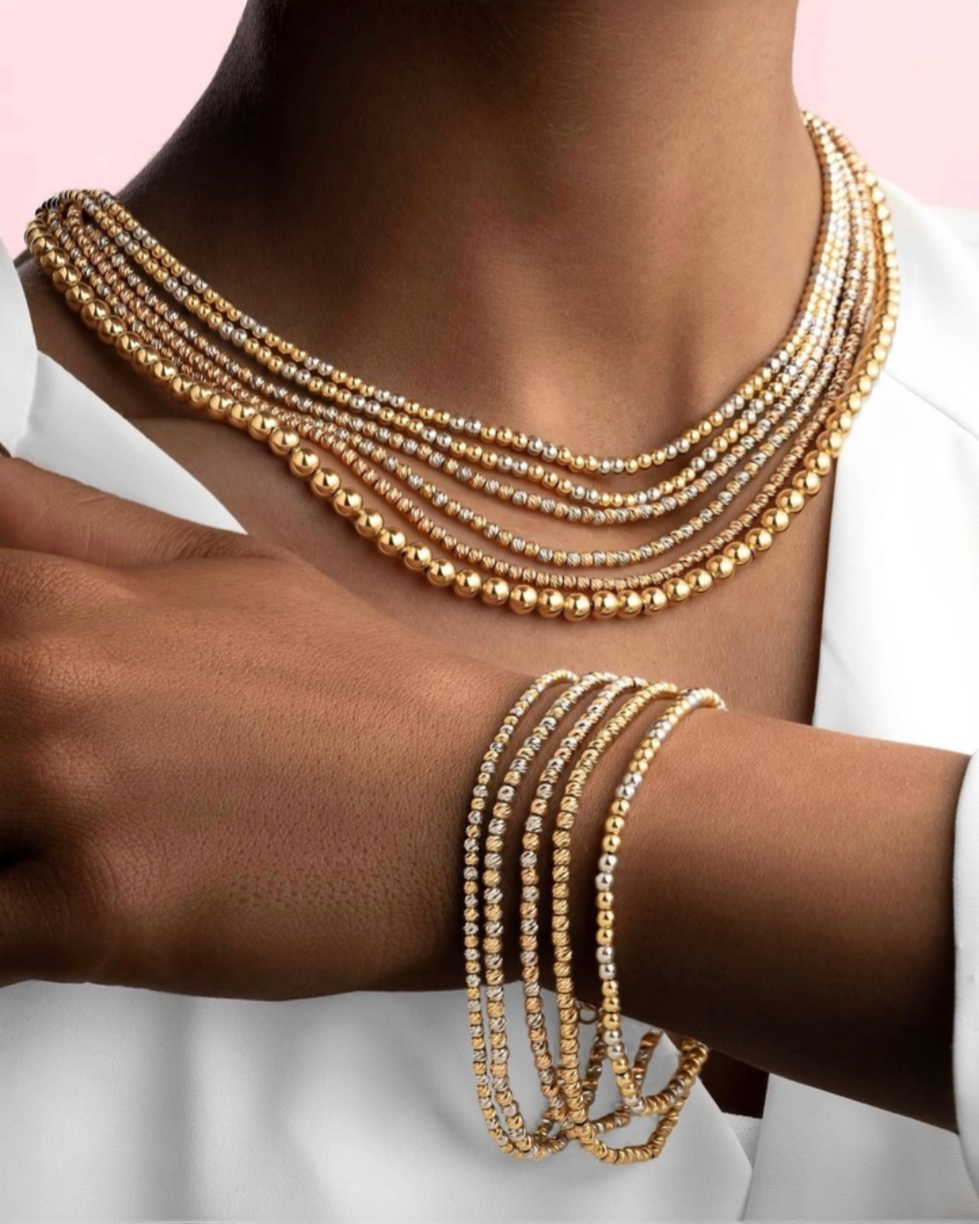 Sad-o Panjah Gooy-e Tala als Kette &amp; Armband-Set – 18k Goldperlen in Gelb und Weiß, stilvoll getragen auf dunkler Haut zur weißen Kleidung